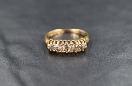 An 18ct gold and diamond five stone ring, the graduated diamonds measuring approximately 0.10ct to