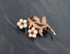 A 9ct rose gold floral brooch having seed pearl and garnet decoration, approx 4.9g gross