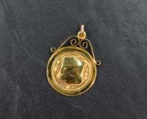 A 9ct gold medallion, having a central vacant shield with decorative engraving with a scroll pendant
