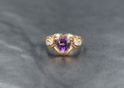 A yellow metal (thought to be 14ct gold) amethyst and diamond ring, the heart cut amethyst in a open