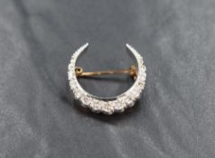 A 9ct gold diamond crescent brooch, the crescent set with fifteen graduated diamonds between