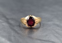 A 9ct gold garnet signet style ring, the central oval cut garnet measuring approximately 2ct, ring