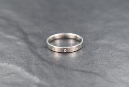 A platinum wedding band having three inset diamond chips, size R & approx 4.7g