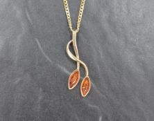 A 14ct gold amber pendant, the twisted vine motif pendant set with two oval amber cabochons, on a