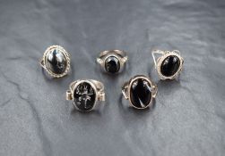 Five silver rings having hematite and onyx stones, various sizes