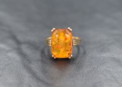 A 9ct gold Baltic amber ring, the shaped rectangular stone in a four claw set mount to reeded