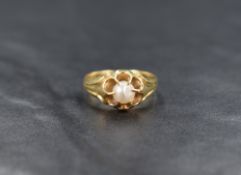 A baroque pearl set yellow metal gypsy ring having moulded detail to shoulders, no marks but