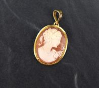 A small conch shell cameo pendant depicting a maiden in profile in a collared 18ct gold mount,