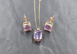 A pair of baguette cut amethyst earrings having 4 claw 9ct gold mounts and posts, with a matched