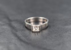 A platinum princess cut diamond solitaire ring, approx 0.56ct in a tension style mount on a wide