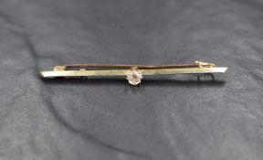 A yellow metal bar brooch stamped 18ct having central diamond, approx 0.25ct & 3.4g