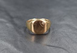 A 9ct gold diamond set signet ring, the rounded panel with a diamond chip to the corner in a star