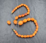 A graduated butterscotch amber bead necklace, having thirty four beads, approximately 2cm to 1cm