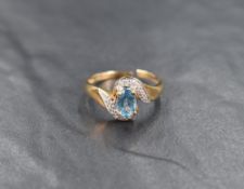 A 9ct gold blue topaz and diamond ring, the central oval cut topaz measuring approximately 0.70,