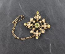 An Edwardian style yellow metal seed pearl and peridot brooch, having pendant loop and safety chain,