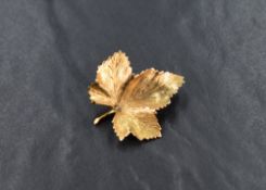 A 9ct gold leaf brooch, the maple motif leaf having a textured surface, with loop for safety chain