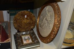 A resin moulded roundel depicting Aurora and Cupid, displayed within a gilt frame, having a diameter