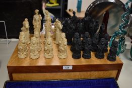 A vintage chess set, comprising a complete set of resin moulded chess pieces, the board measures