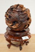 A 19th/20th Century Chinese carved hardwood Zodiac ball, featuring a dragon and raised on a hardwood