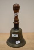 A 19th/20th Century hand held bell with turned wood handle, measuring 25cm high