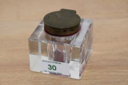 A cut glass ink well of cube form with bevelled edges and metal lid, measuring 6cm high