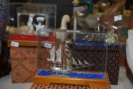 A Chinese white metal filigree model of a junk ship, displayed under glass, case measurements 16cm x