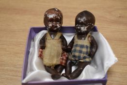Two miniature bisque porcelain jointed dolls with clothing, the largest measures 8cm high