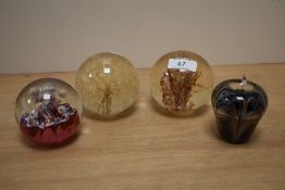 A 20th Century Caithness Myriad glass paperweight, measuring 9cm high, and three other