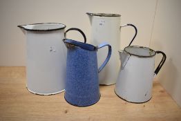 Four mid-20th Century enamelled kitchen jugs to include a mottled blue jug, the largest measures