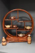 A Chinese stained wood display stand of circular form with a selection of terracotta and glazed