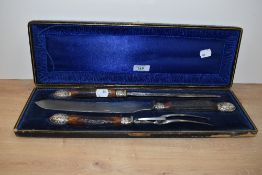 A cased three piece horn handled carving set by Isaac Ellis & Sons of Sheffield