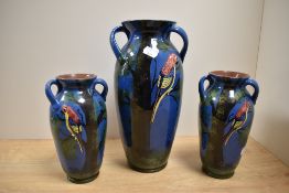 A group of three decorative Longpark pottery Torquay ware vases, one large and a pair of smaller,