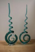 A pair of 20th Century art glass swirl sculptures raised on rectangular plinths, measuring 55cm