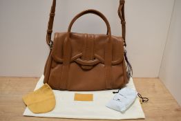 A ladies tan leather Radley of London handbag, with foliate lined interior, material outer bag and