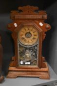 A late 19th Century American Gingerbread mantel clock by the Ansonia Clock Company, the mahogany