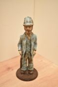 A studio pottery figure of a farmer with shotgun, mottled glaze to garments, standing at 23cm,