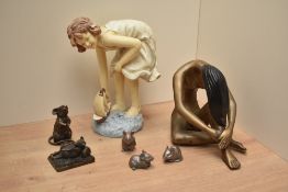 A decorative cast resinous figure of a small girl and model sailing ship, indistinct impressed