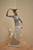A large Lladro porcelain style 'Country Woman' figurine, modelled as a young woman balancing a