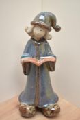 A large studio pottery mottled glazed terracotta figurine, a young girl in nightdress holding an