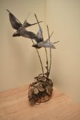 A large Gordon H Griffiths patinated metal study depicting swallows in flight above brambles,