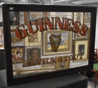 A Guinness Extra Stout advertising mirror, within a moulded wooden frame, measuring 55cm x 78cm, &