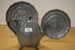 Two reproduction pewter dishes, each embossed with armorial detail and sold together with a pewter
