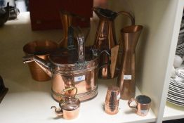 A vintage copper watering can in the design of Dr Christopher Dresser sold alongside a copper flower