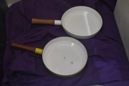 Two vintage Dansk designs France IHQ skillet pans with wooden handles, in vibrant yellow and white