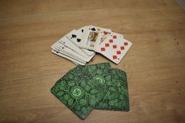 A bundle of vintage playing cards, the reverse printed with a Swastika design