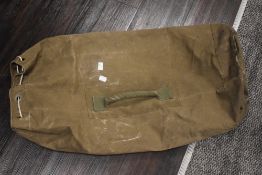 A vintage green canvas military duffle bag, measuring 80cm long