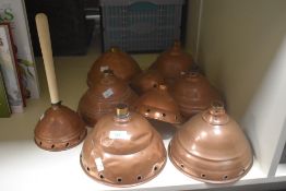 A collection of nine copper Posser heads, various sizes, mainly domed circular with pierced