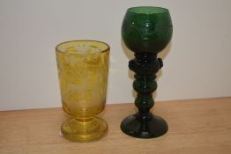 A Bohemian green etched glass wine glass, measuring 19cm high, and a 19th Century Bohemian amber