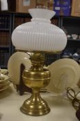 A late 19th Century brass oil lamp with a white glass shade and chimney, measuring 50cm high