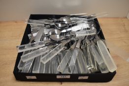 A selection of contemporary stainless steel and clear Perspex flatware and cutlery, eight of each